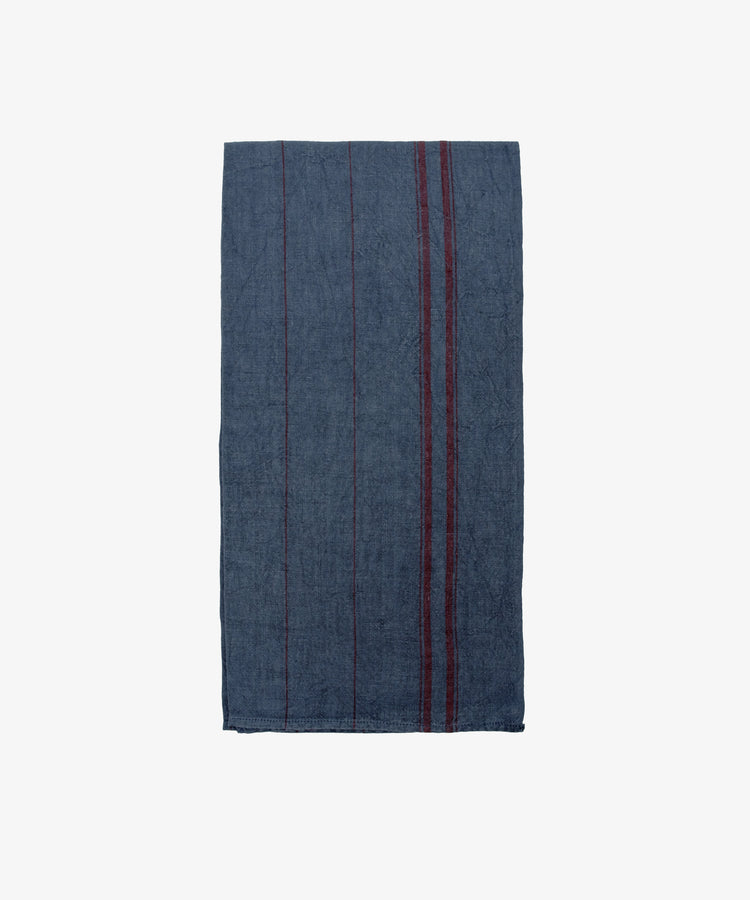 The French Vintage Tea Towel is a dark blue rectangular cloth with subtle vertical red stripes on the right side, inspired by vintage linen tea towels and shown on a plain white background.