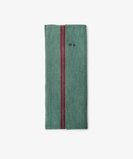 The French Vintage Tea Towel is a folded green cloth napkin with a vertical red center stripe and delicate 