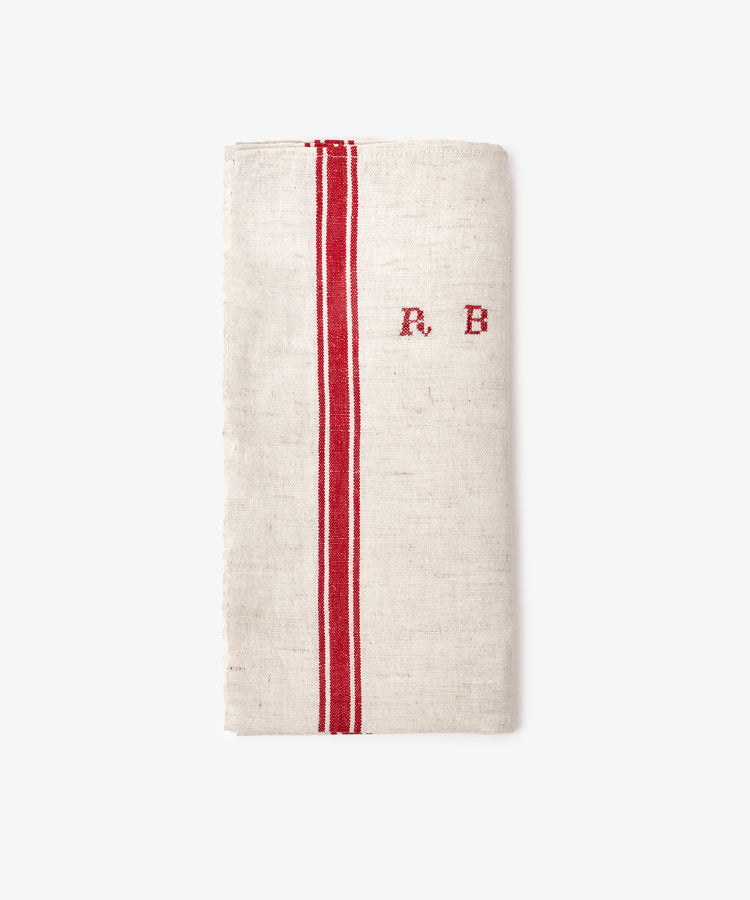 A French Vintage Tea Towel in folded linen, featuring two vertical red stripes and embroidered 