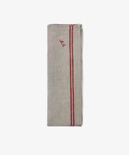 A French Vintage Tea Towel in beige linen, folded, featuring two red stripes and small embroidered red initialsâ€”evoking Provence charm and classic vintage tea towelsâ€”displayed on a plain white background.