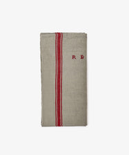 The French Vintage Tea Towel is a folded beige linen with two vertical red stripes and 
