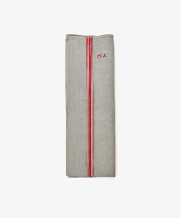 The French Vintage Tea Towel, a folded gray linen with red stripes and MA embroidery on the upper right, brings Provence charm to your kitchen.