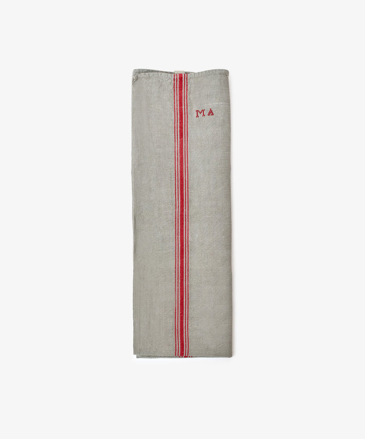 The French Vintage Tea Towel, a folded gray linen with red stripes and MA embroidery on the upper right, brings Provence charm to your kitchen.