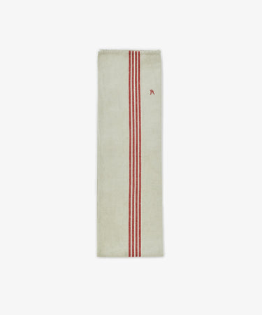 The French Vintage Tea Towel is a rectangular beige linen towel inspired by Provence, featuring three vertical red stripes and a small red embroidered letter A—ideal for adding classic charm to your kitchen.