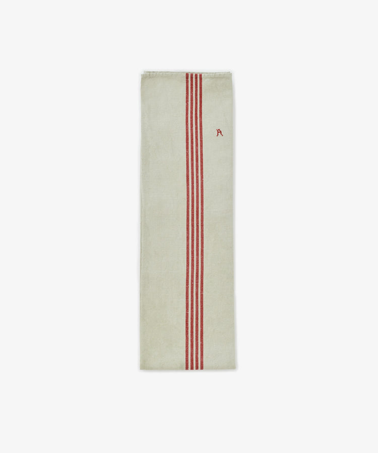 The French Vintage Tea Towel is a rectangular beige linen towel inspired by Provence, featuring three vertical red stripes and a small red embroidered letter A—ideal for adding classic charm to your kitchen.