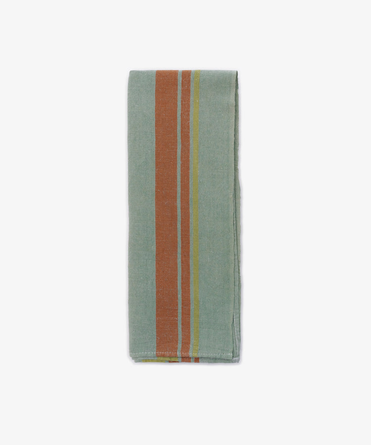 The French Vintage Tea Towel, a folded light blue-green cloth napkin with vertical orange and yellow stripes on one side, is displayed against a white kitchen background.