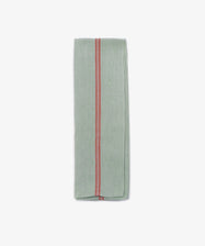 The French Vintage Tea Towel, a folded light green linen with a central red stripe, brings Provençal charm and vintage style to your kitchen. Shown here on a plain white background.