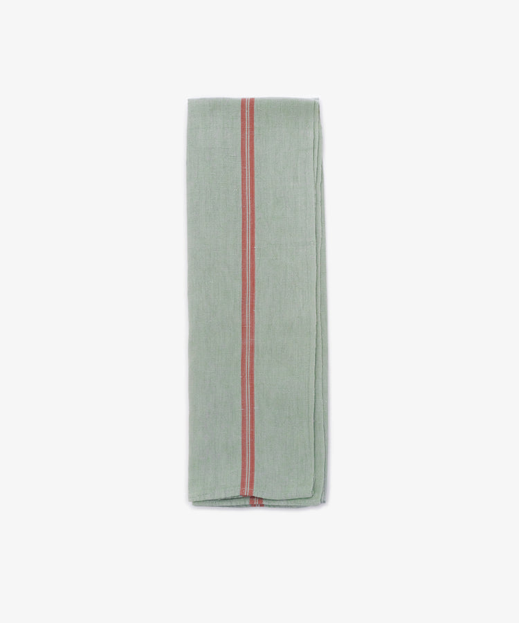 The French Vintage Tea Towel, a folded light green linen with a central red stripe, brings Provençal charm and vintage style to your kitchen. Shown here on a plain white background.