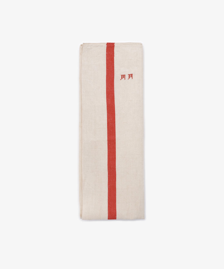 The French Vintage Tea Towel, a folded beige linen napkin with a vertical red stripe and small red embroidered letters, evokes classic vintage style and is displayed on a plain white background.