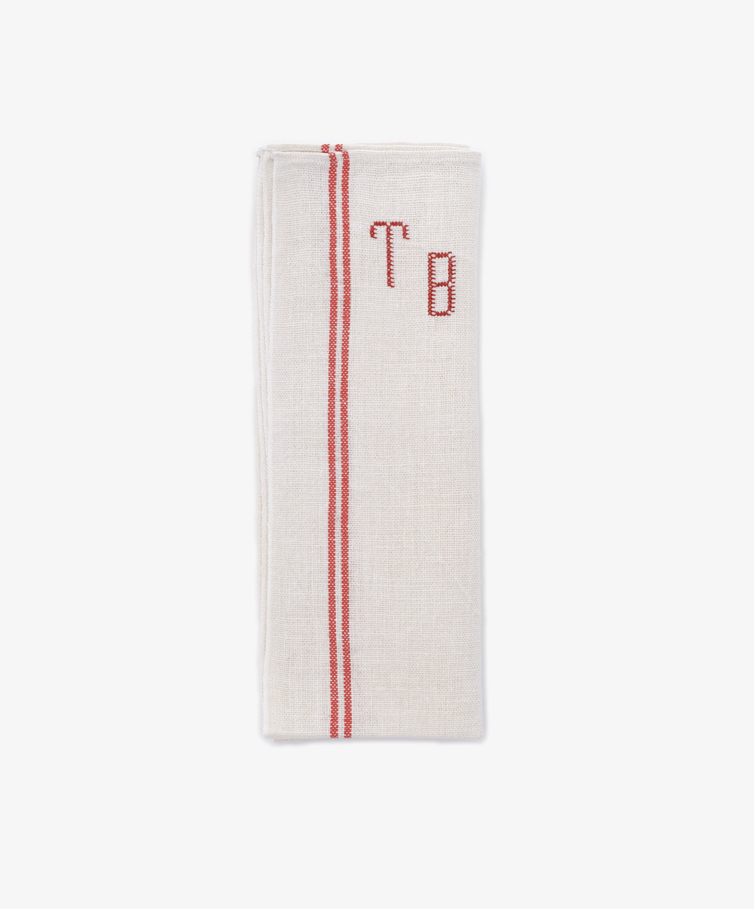 The French Vintage Tea Towel is a folded beige napkin with red embroidered initials 