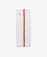 The French Vintage Tea Towel features two parallel red stripes and small red embroidered initials near the top left, styled folded on a plain light background.