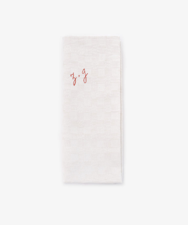 A French Vintage Tea Towel featuring a white folded cloth napkin with 