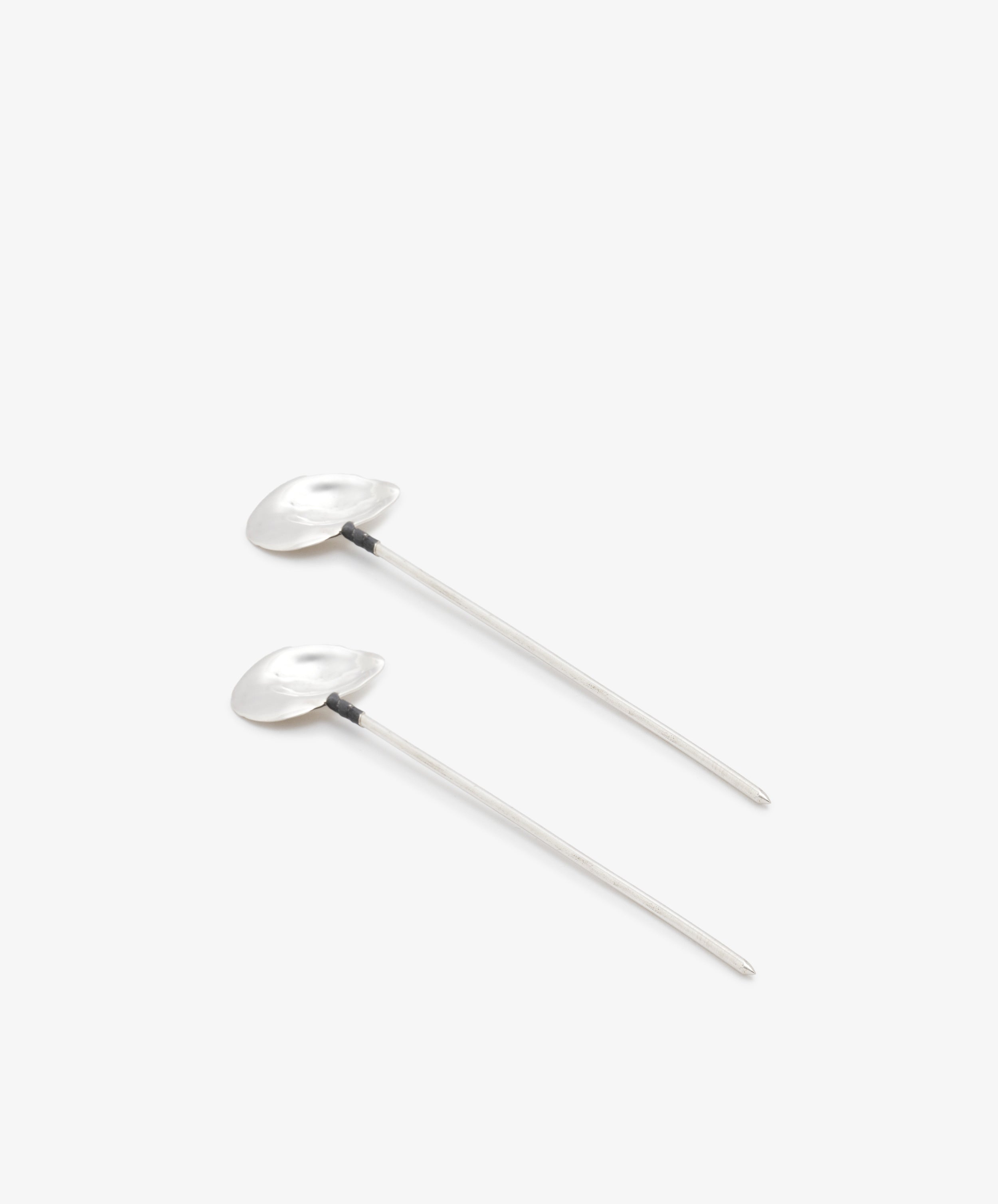 Oyster Shell Cocktail Sticks. Set of 2 sterling silver stirrers with organic shaped shell tops, angled side view.