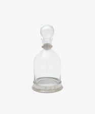 The Alec Decanter is a clear glass decanter with a round pewter stopper, pewter collar and base, all engraved with decorative markings and the letter P.