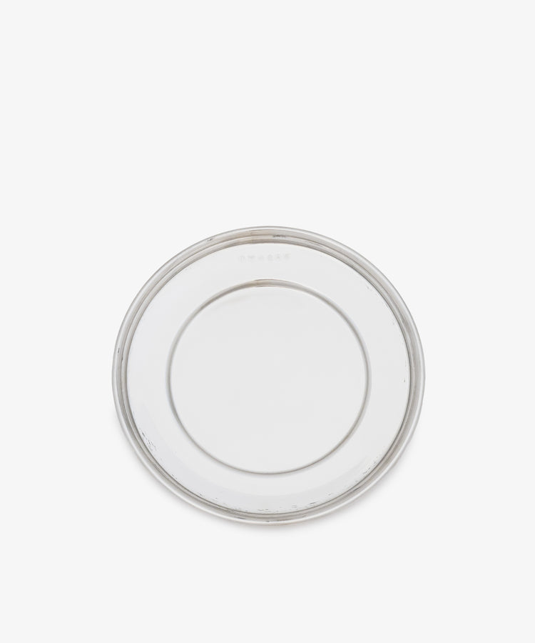 The Greta Small Bread Plate—a clear, round glass plate with a simple design, shown from above on a white background—is a timeless essential for any setting.