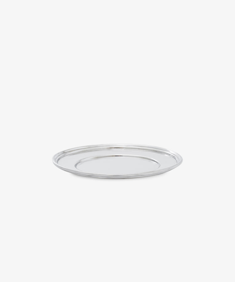The Greta Small Bread Plate—a round, silver metal serving tray—offers timeless elegance, shown on a plain white background.