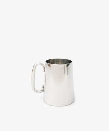The Harry Tankard, a plain stainless steel mug with a handle, is displayed against a white background, adding contemporary style to everyday drinkware.