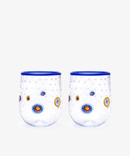 The Girotondo Glass Set of 2 features clear tumblers with blue rims, a textured surface, and vibrant circular patterns inspired by Murano glass and Venetian craftsmanship.