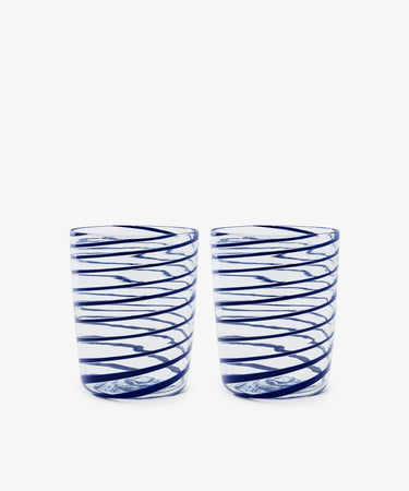 The Spirale Glass, Set of 2, features clear Murano glasses with blue spirals, displayed side by side on a white background to highlight the refined beauty of Italian craftsmanship.
