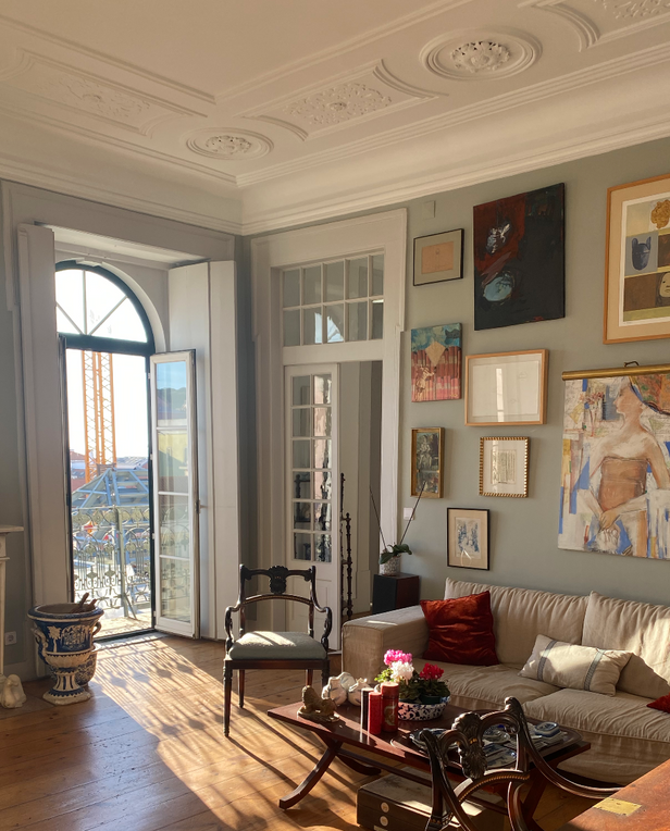 room with paintings and sofa and balcony