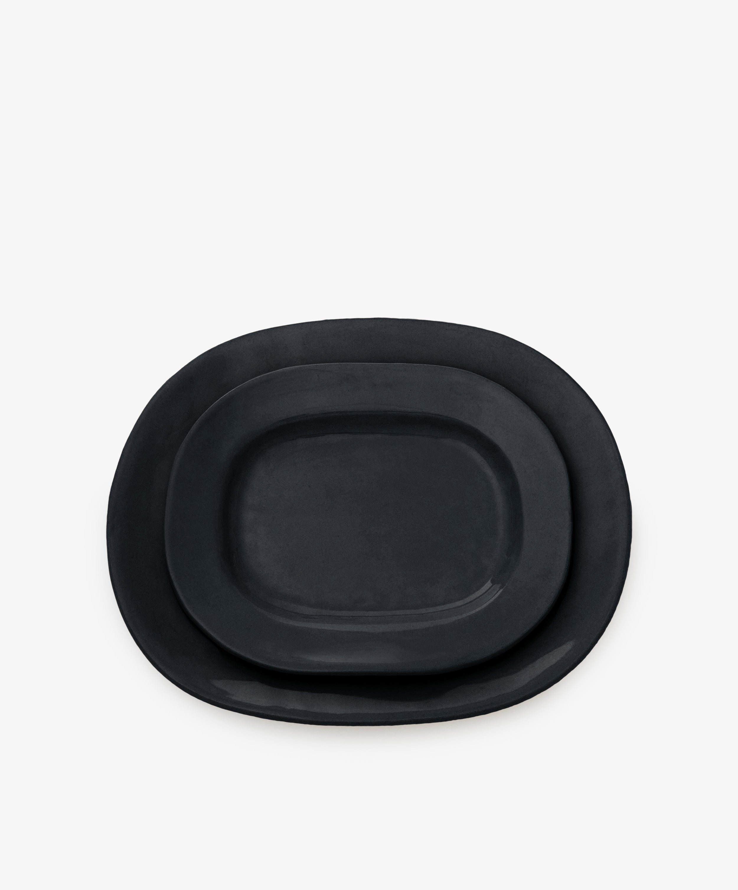 Two black, rectangular ceramic Small Rectangular Platters, ideal as modern tableware or stylish serving platters, are stacked together against a plain white background.