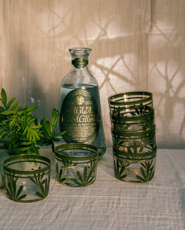 glasses with green motif and alcohol bottle