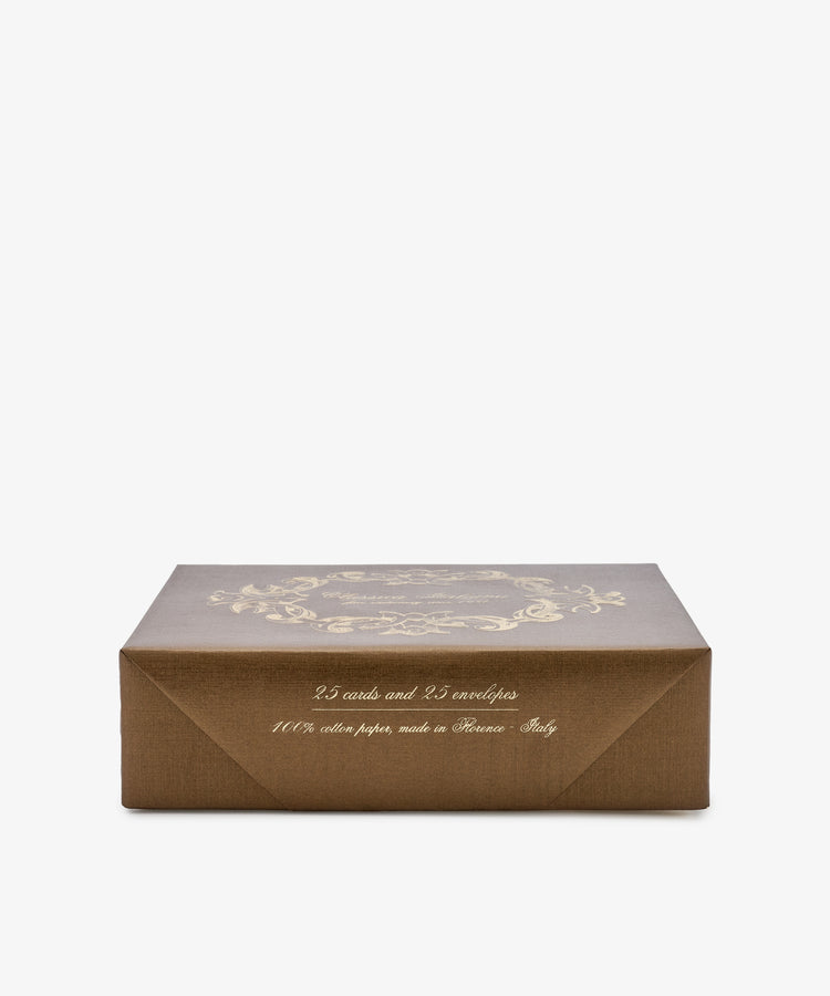 A brown rectangular box with gold decorative text, labeled as a “Bordered Correspondence Card & Envelope, Set of 25,” contains 25 wedding thank-you cards and 25 cream envelopes, made in Italy.