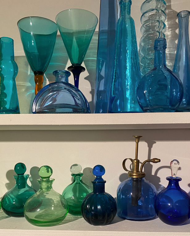blue and green glassware and vases on shelves