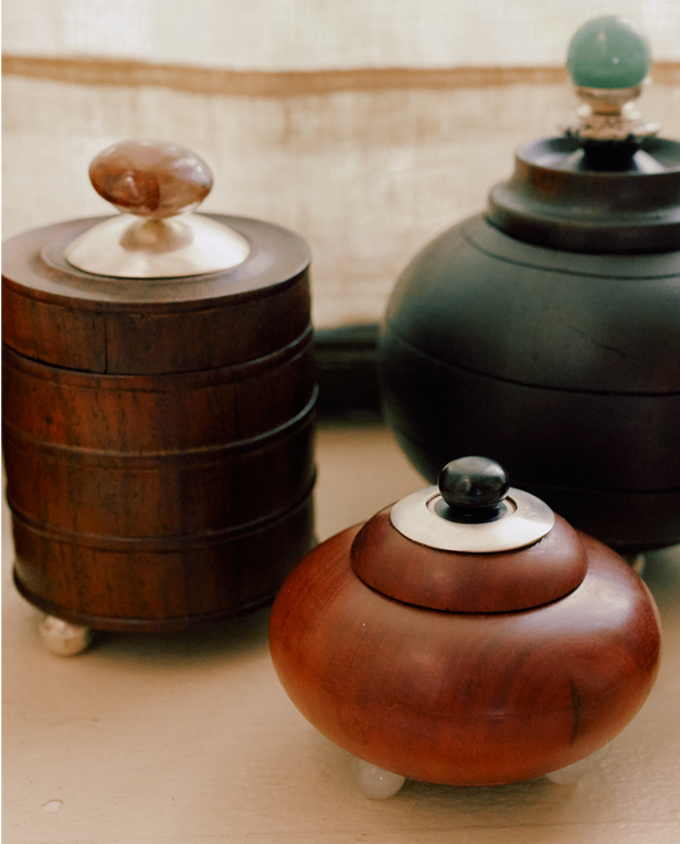Three wooden containers with lids on a light background
