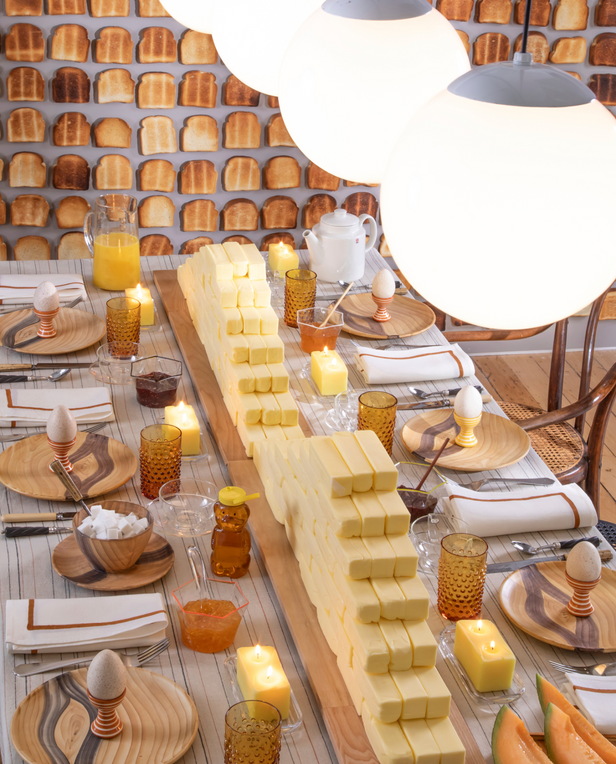 Breakfast table with eggs, juice, and butter centerpiece.