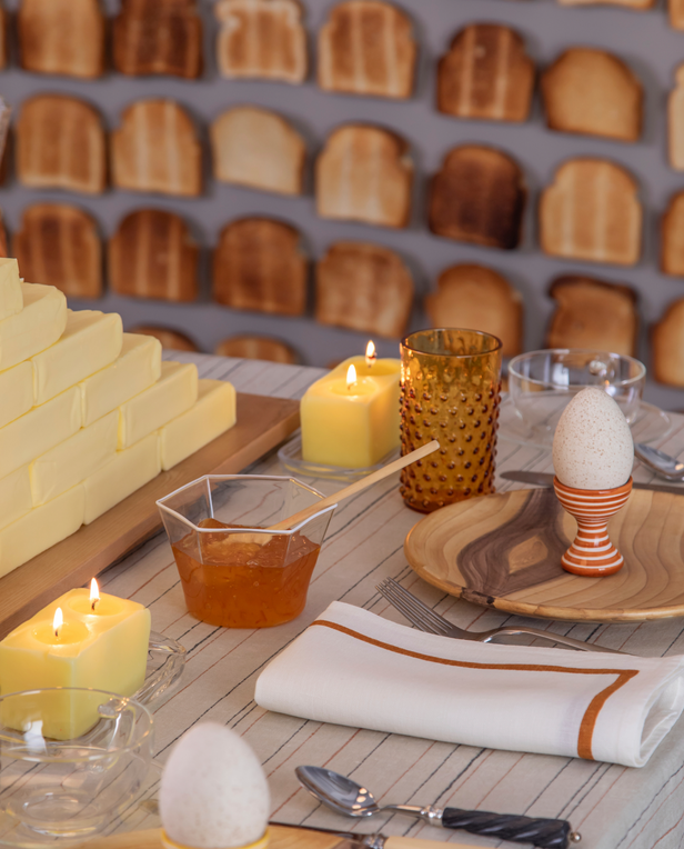 Breakfast table with eggs, juice, and butter centerpiece.