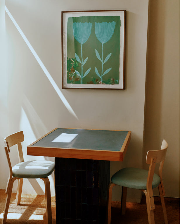 floral painting on wall over table with two chairs