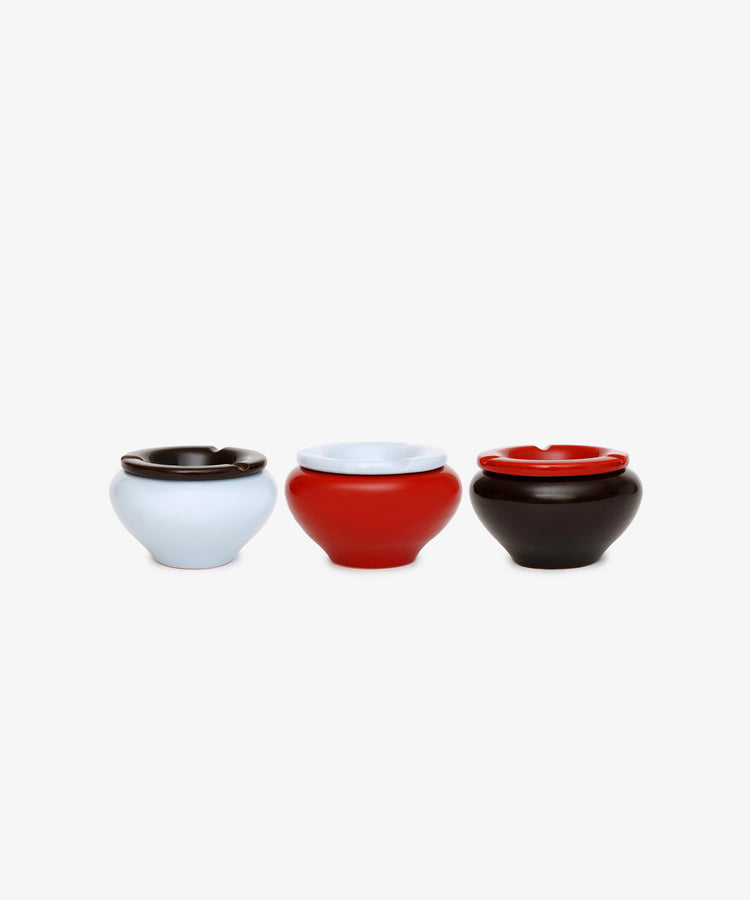 Three Mix & Match Ashtrays—chunky ceramic pieces in light blue, red, and dark brown, handmade in Italy—are arranged side by side on a plain white background.