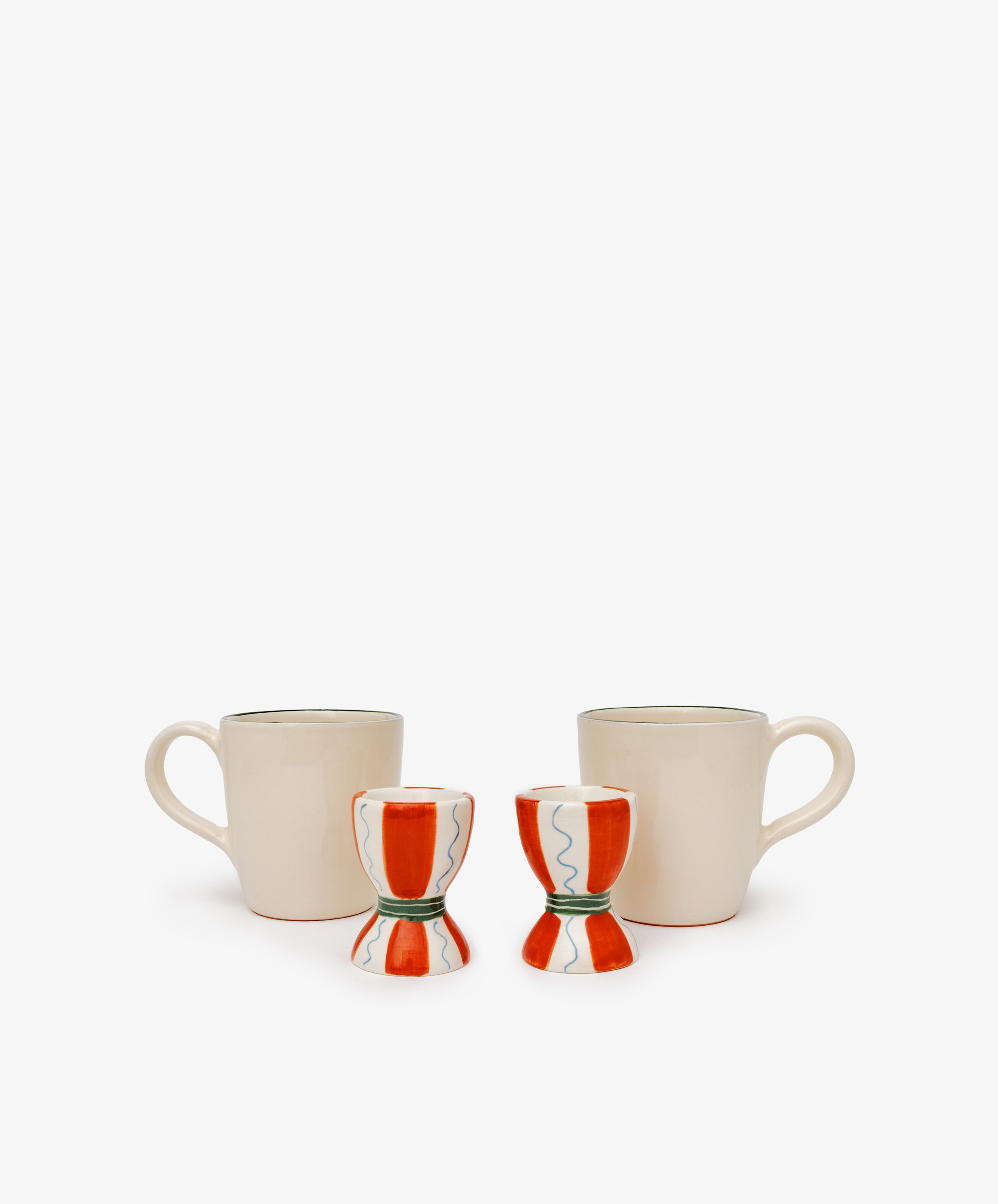 The Breakfast for Two Bundle features two cream coffee mugs with handles and two red and white ceramic egg cups, creating a simple yet charming Valentine’s Day breakfast scene on a plain white background.