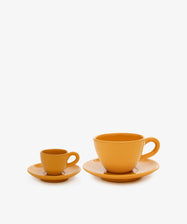 The Gio Espresso Bundle, featuring two orange ceramic cup and saucer sets in small and large sizes, sits side by side on a white background—ideal for serving drip coffee or café au lait.