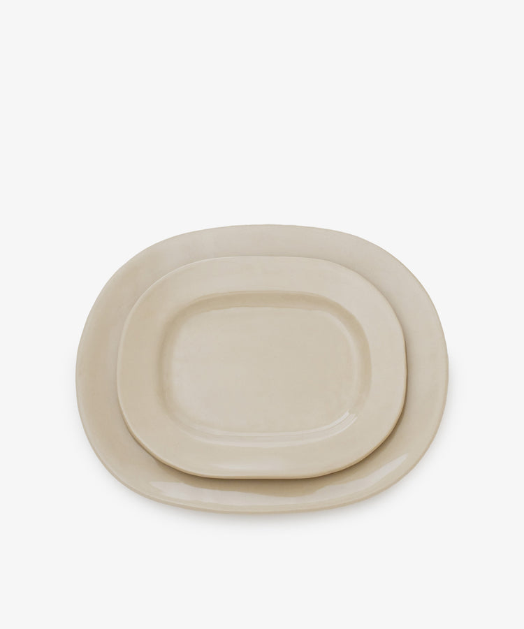 A large beige rectangular ceramic serving platter is displayed against a plain white background, highlighting its contemporary slipware style that’s perfect for modern dining.