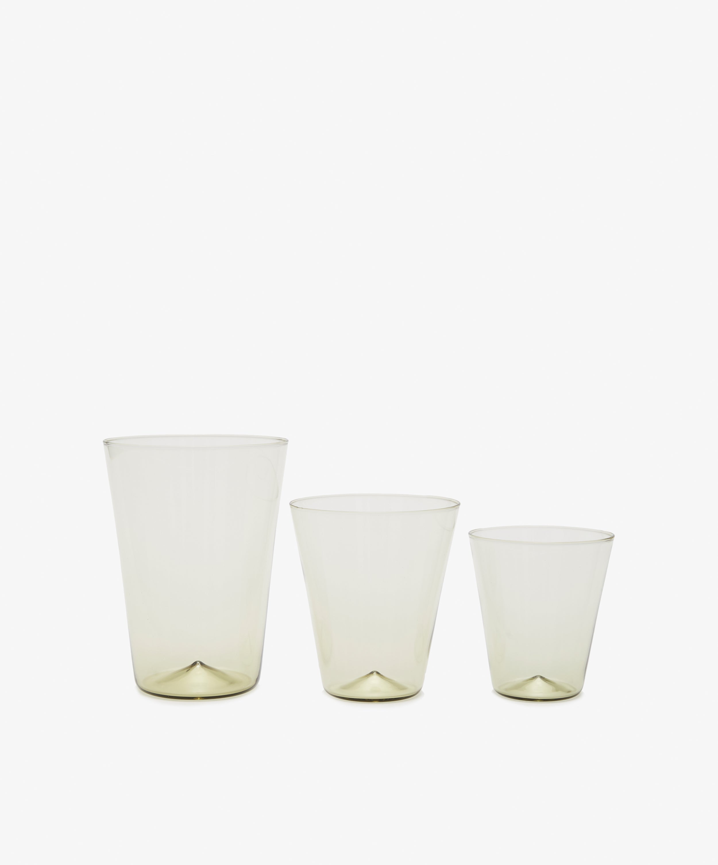 Grouping of three sized drinking glasses in smoke green.