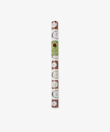 A rolled sheet of Intaglio Stripe Gift Wrap in brown, featuring a repeating pattern of white circles and line drawings, labeled with a green Parvum Opus sticker.