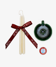 The Wax & Wick Bundle features two white tapered candles with a maroon PORTA ribbon, a green ceramic holder, and a small tin of candle adhesive displayed on a white background.