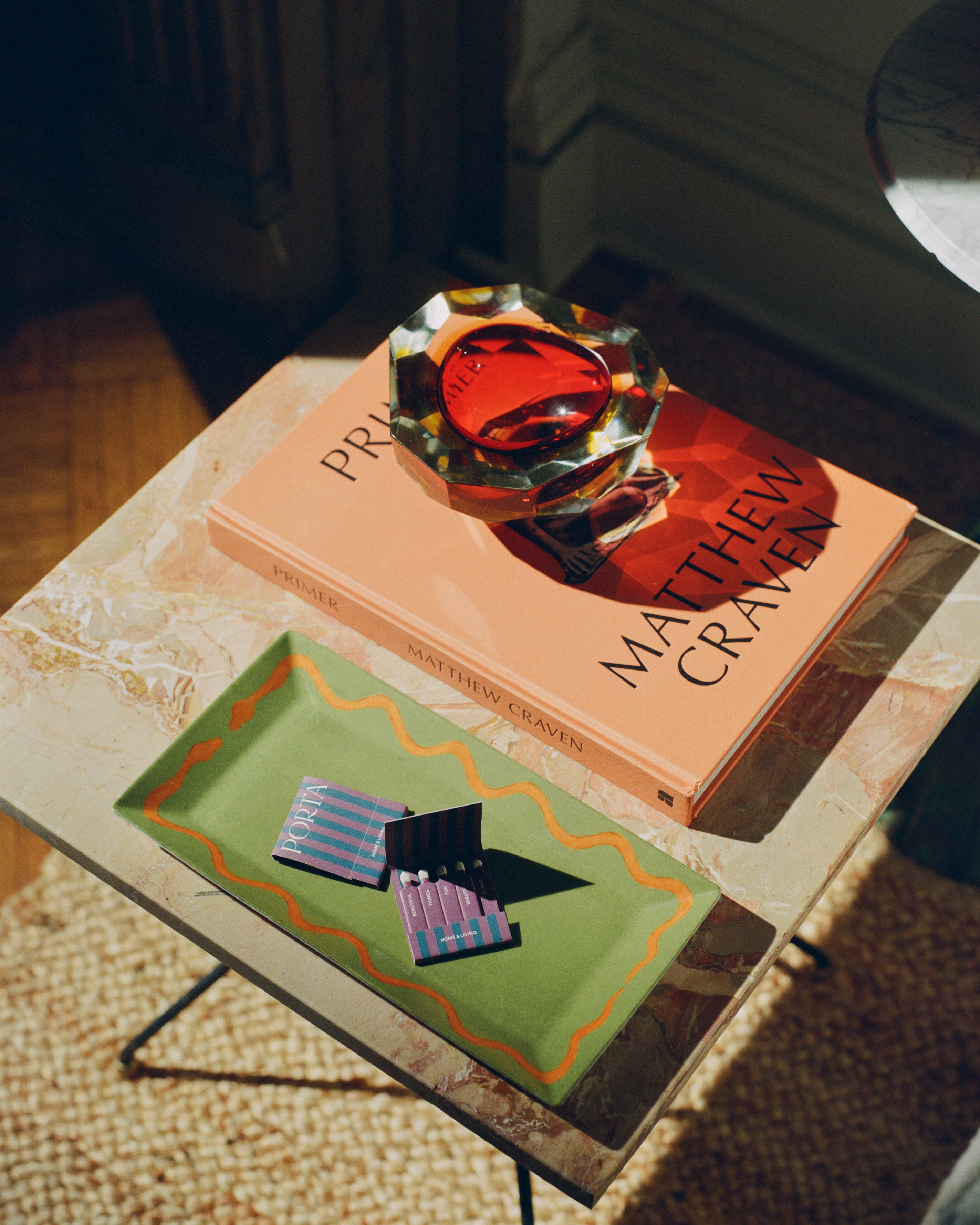 Hand Painted Double Serpent Tray shown on coffee table next to book and glass ashtray.