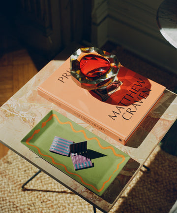 Hand Painted Double Serpent Tray shown on coffee table next to book and glass ashtray.