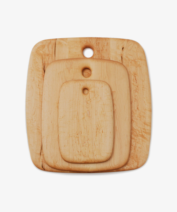 Nested maple chopping boards in three different sizes, overhead view.