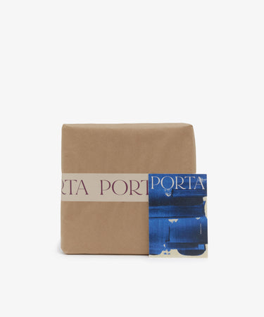Brown paper package with Porta-branded tape and blue Porta postcard.