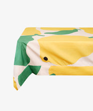 Main Squeeze Tablecloth by Porta x Liv Lee. White cloth on floating table printed with oversized yellow and green citrus motif.