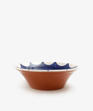 Stella Serving Bowl. Glazed terracotta bowl with white rim and dark blue design, side view.