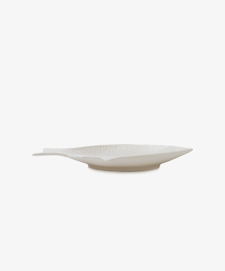 The Peixe Platter, a white ceramic plate shaped like a fish, adds creativity to your table and stands out against a plain white background.