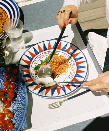Palio Dinner plate on table with spaghetti and cutlery.