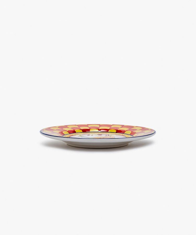 Palio Small Plate in white glazed ceramic with red and yellow designs, side view.