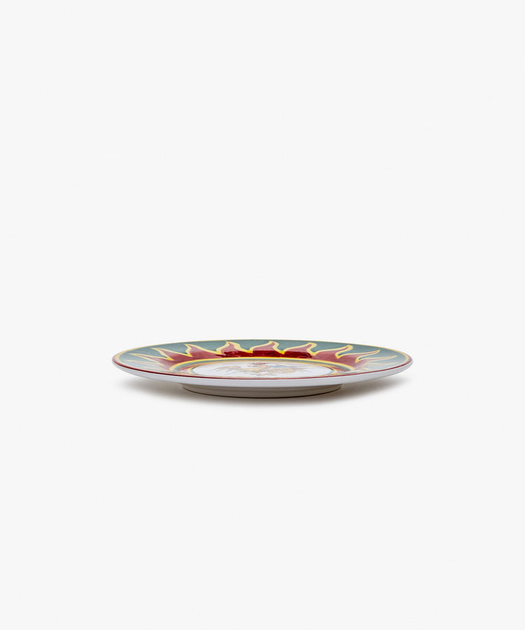 Palio Small Plate in white glazed ceramic with red and green designs, side view.