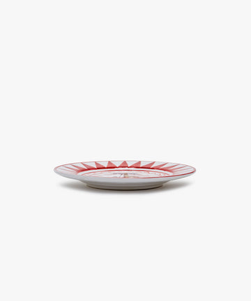 Palio Small Plate in white glazed ceramic with red designs, side view.